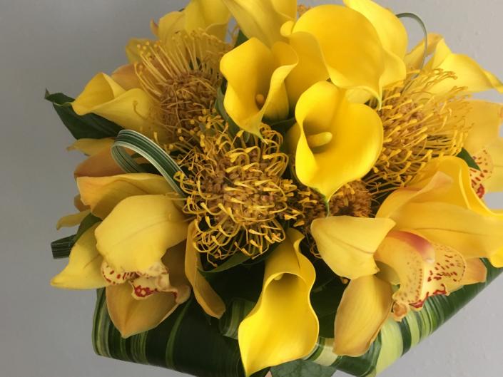 Stand out on your big day with this brides bouquet filled with Yellow calla lillys, yellow protea pincushions, and yellow cymbidium orchids.
