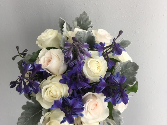 Bride or Bridesmaid Bouquet using dark blue delphinium, blush and ivory roses, accented with dusty miller.