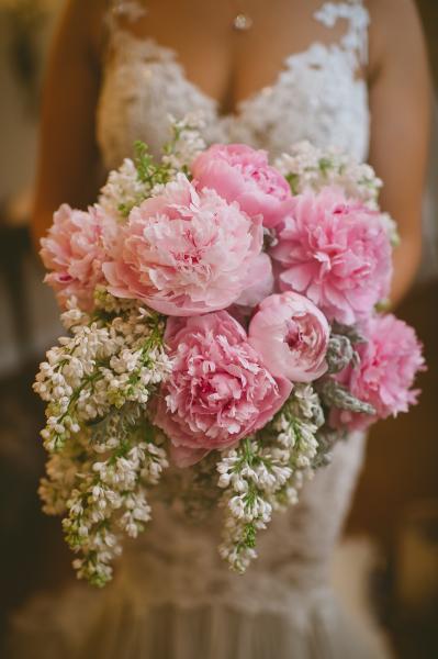 A spring bouquet featuring pale pink peony's, white lilac and dusty miller greenery