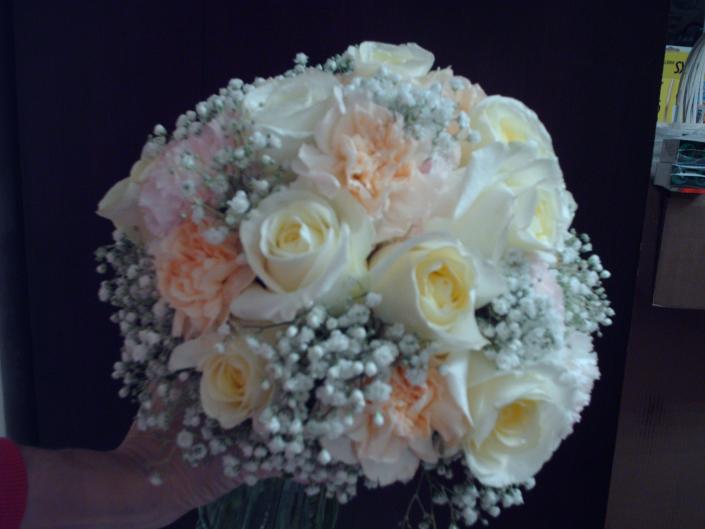 Peach and pale pink carnations, creme roses, and baby's breath