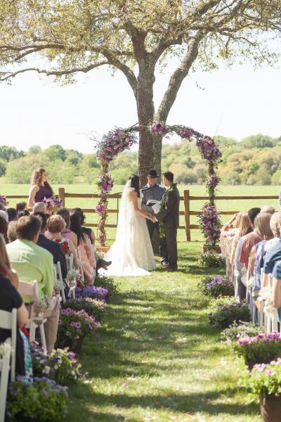 Rustic arch with floral accents in lavender and purples. A mix of roses, carnations, mums, alstromeria, purple statice and babys breath.